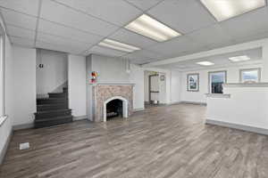 Unfurnished living room featuring a drop ceiling and wood-type flooring