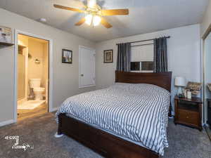 Bedroom with dark colored carpet, ceiling fan, and a textured ceiling