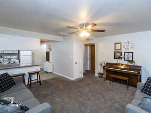 Carpeted living room with ceiling fan