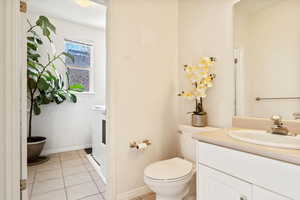 Bathroom featuring tile patterned flooring, vanity, and toilet