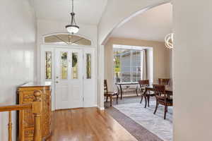 Foyer featuring light wood-type flooring and lofted ceiling