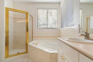 Bathroom with separate shower and tub, tile patterned floors, and a healthy amount of sunlight