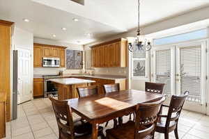 Tiled dining room with a textured ceiling and an inviting chandelier