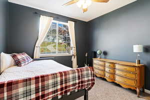 Carpeted bedroom featuring ceiling fan