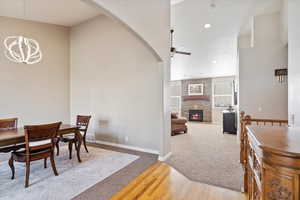 Dining room featuring ceiling fan with notable chandelier, light hardwood / wood-style floors, and a fireplace