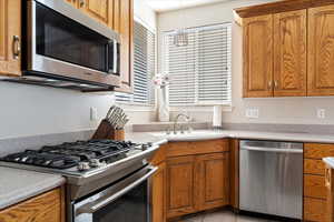 Kitchen with light tile patterned flooring, stainless steel appliances, and sink