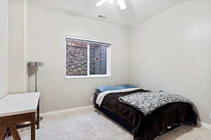 Carpeted bedroom featuring ceiling fan