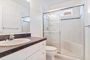 Bathroom with vanity, toilet, and walk in shower