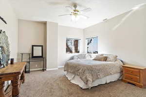 Carpeted bedroom featuring ceiling fan and a textured ceiling