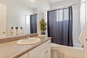 Full bathroom featuring tile patterned flooring, vanity, shower / bath combination with curtain, and toilet