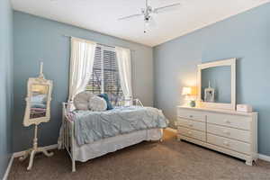 Carpeted bedroom featuring ceiling fan