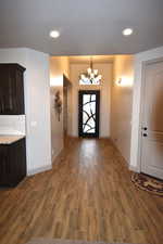 Entrance foyer featuring dark hardwood / wood-style flooring and an inviting chandelier