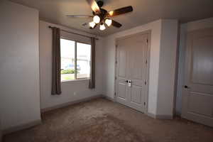 Unfurnished bedroom featuring light carpet, a closet, and ceiling fan