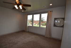 Carpeted spare room with ceiling fan