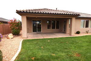 Rear view of property with a yard and a patio area