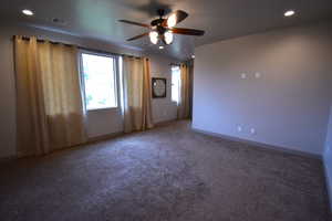 Carpeted empty room featuring ceiling fan