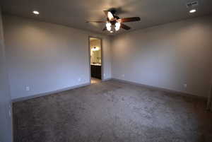 Carpeted spare room featuring ceiling fan