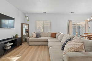 Living room with a chandelier and light wood-type flooring