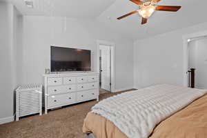 Bedroom featuring ceiling fan, lofted ceiling, and carpet floors