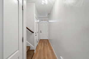 Hallway with a textured ceiling and light wood-type flooring