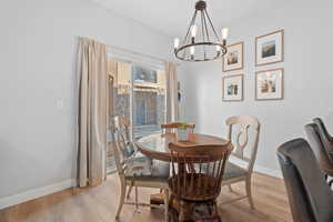 Dining area with a notable chandelier and light wood-type flooring