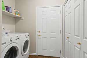 Washroom featuring washer and clothes dryer and dark wood-type flooring