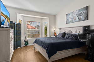 Bedroom featuring hardwood / wood-style floors and vaulted ceiling