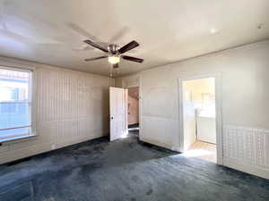 Empty room featuring ceiling fan, dark colored carpet, and washer / dryer