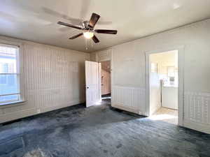 Unfurnished bedroom with washer / clothes dryer, ceiling fan, and dark colored carpet