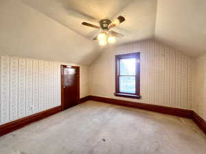 Bonus room with carpet flooring, a textured ceiling, and vaulted ceiling