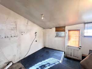 Unfurnished room featuring lofted ceiling