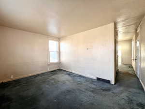 Carpeted spare room featuring a textured ceiling