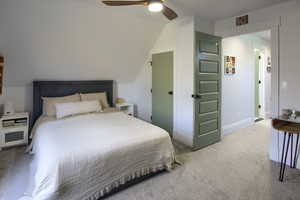 Carpeted bedroom featuring ceiling fan and lofted ceiling