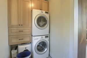 Laundry area with cabinets and stacked washer / drying machine