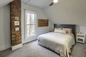 Carpeted bedroom with ceiling fan and vaulted ceiling