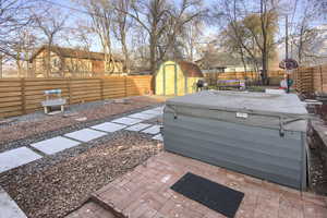 View of yard with a shed, a hot tub, and a patio area