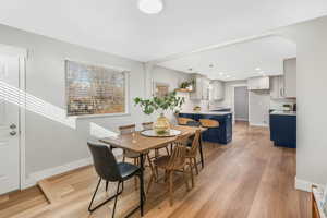 Dining room with light hardwood / wood-style floors and sink