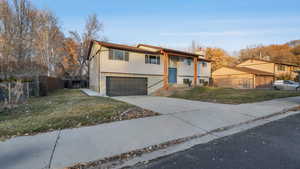 View of front of property featuring a garage and a front yard