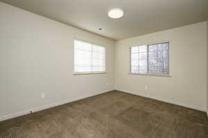 Spare room featuring dark colored carpet