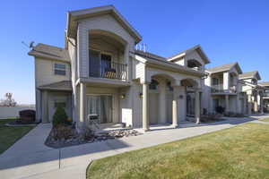 View of front of house featuring a balcony and a front lawn