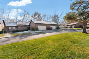 View of side of home with a lawn, an outdoor structure, and a garage