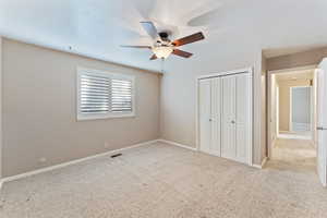 Unfurnished bedroom featuring light carpet, a closet, and ceiling fan