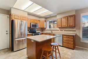 Kitchen featuring decorative backsplash, sink, a kitchen island, and stainless steel appliances