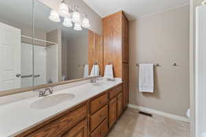 Bathroom with tile patterned flooring, a shower, vanity, and toilet