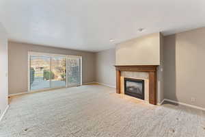 Unfurnished living room featuring a fireplace and light colored carpet