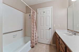 Bathroom featuring tile patterned floors, vanity, and shower / tub combo