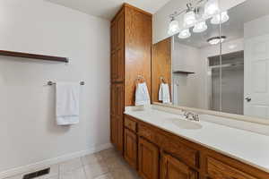 Bathroom with tile patterned floors, vanity, and an enclosed shower