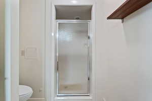 Bathroom with toilet and a shower with door