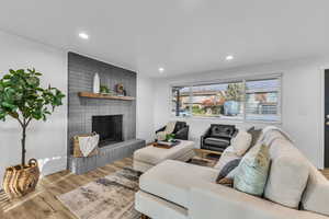 Living room with hardwood / wood-style floors and a brick fireplace