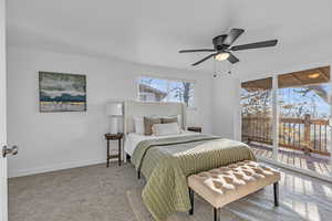 Carpeted bedroom featuring access to outside and ceiling fan